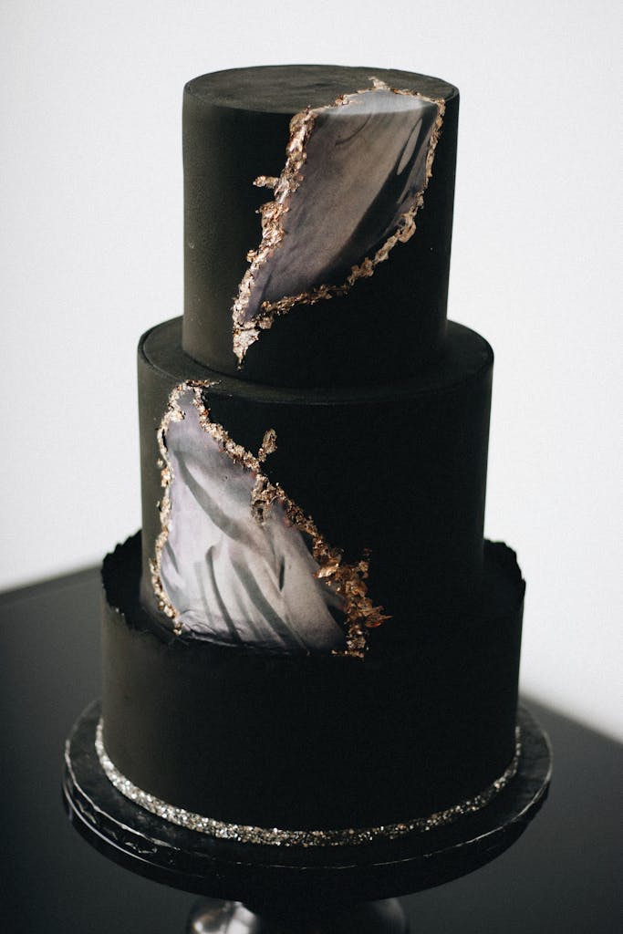 A sophisticated black geode cake featuring metallic accents and artistic design.